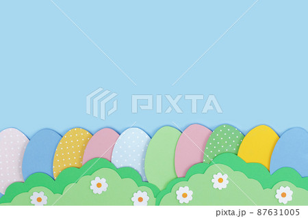 Happy Easter. Painted Easter eggs cutting out paper and grass made of green paper on blue background. 87631005