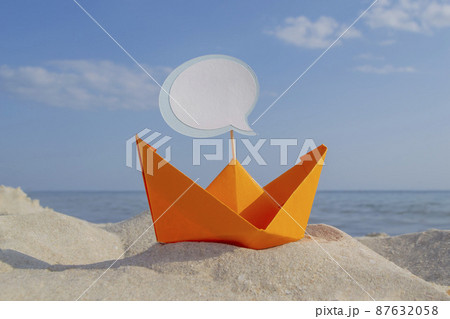 Orange Paper Boat on Sandy Seashore Close-up Small Boat from Paper on Background 87632058