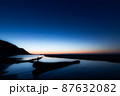 夜明けが始まる日の出直前の幻想的な海岸の砂浜と海 87632082