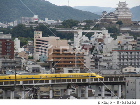 後方に姫路城が見える町並みを通過するドクターイエロー 87636262