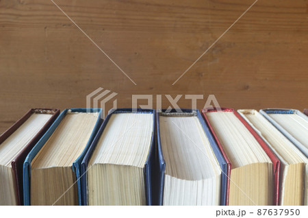 Stack of the books rests upon wooden regiment Stack of the books rests upon wooden regiment 87637950