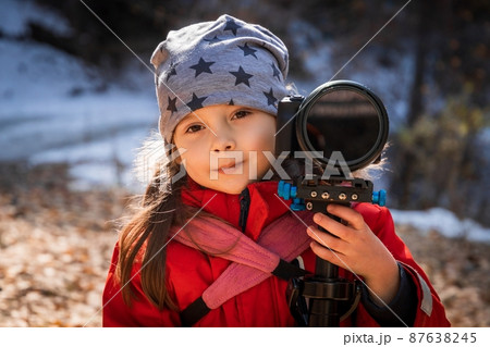 Portrait of little girl videographer in star hat outdoors with steadicam Portrait of little girl videographer in star hat outdoors with steadicam 87638245