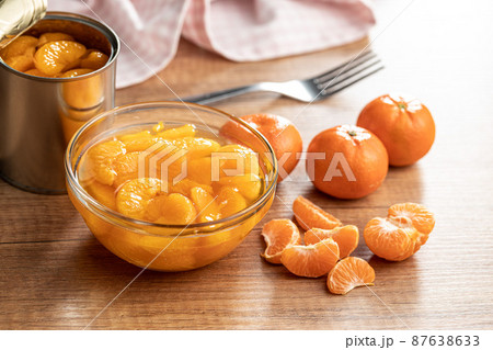 Canned tangerine. Pickled mandarin fruit in bowl on wooden table. 87638633