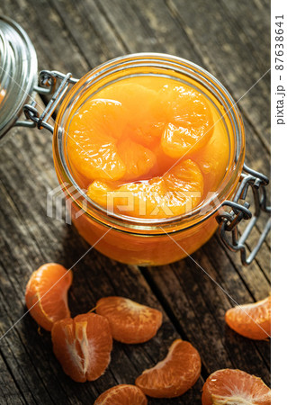 Canned tangerine. Pickled mandarin fruit in jar on wooden table. Canned tangerine. Pickled mandarin fruit in jar on wooden table. 87638641