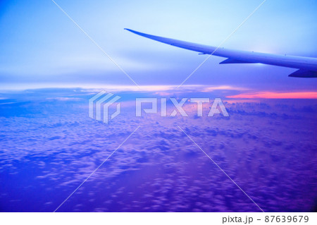 ピンクと紫の綺麗なグラデーションの飛行機から見る朝日 87639679