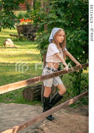 Teenage girl posing near iron fencing in green park of rural mansion 87643188