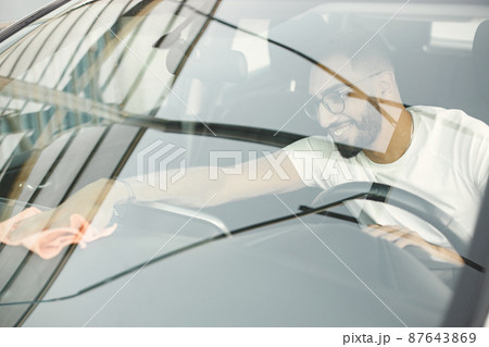 Indian man polishing inside his white car with a rug Indian man polishing inside his white car with a rug 87643869