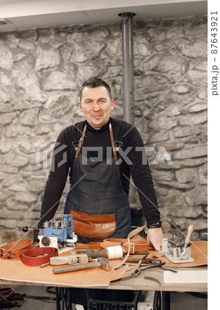Portrait of a leather craftsman standing in his workspace 87643921