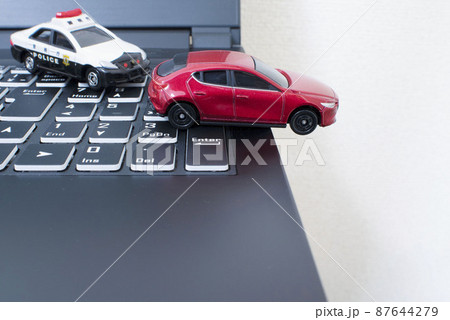 黒いキーボードと1台のパトカーと赤い車 87644279