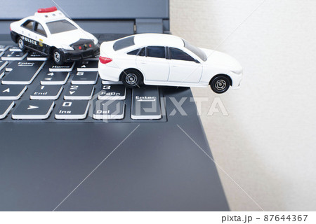 黒いキーボードと1台のパトカーと白いセダン 87644367