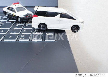 黒いキーボードと1台のパトカーと白いミニバン 87644368