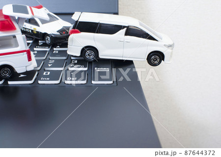 黒いキーボードと1台のパトカーと1台の救急車と白いミニバン 87644372