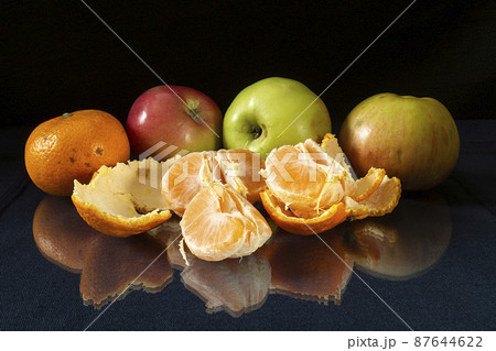 Segments of the tangerine on glass table with reflection 87644622