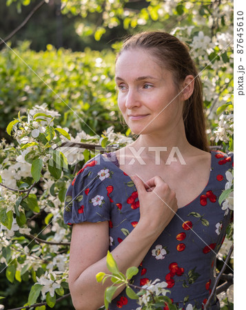 Beautiful Young woman without makeup in a spring park among flowering trees Beautiful Young woman without makeup in a spring park among flowering trees 87645610