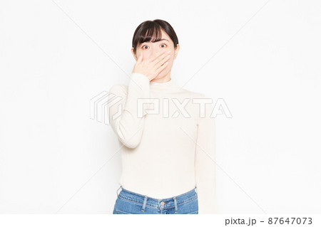 白い背景の前に立って驚いている女性 白い背景の前に立って驚いている女性 87647073