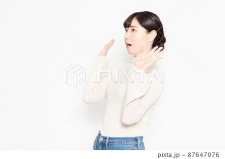 白い背景の前に立って驚いている女性 白い背景の前に立って驚いている女性 87647076