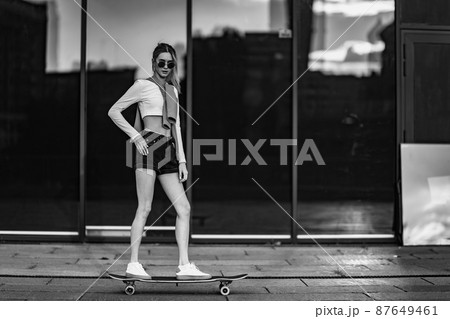 Young woman rides a longboard. 87649461