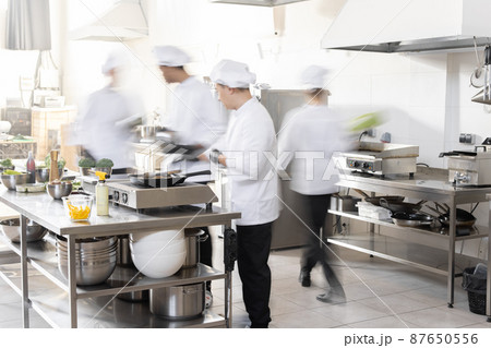 Chef cooks working in professional kitchen 87650556