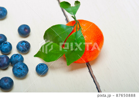 tangerine and blueberry on white table 87650888