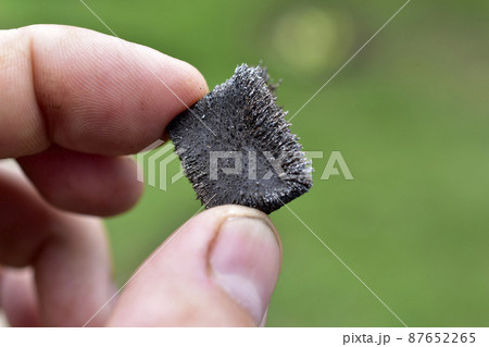 Metal magnet in the iron crumb in the hands 87652265