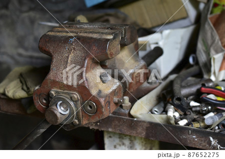 Red massive locksmith iron vise on an iron table 87652275