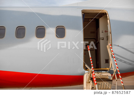 Passenger airplane with open entrance door at airport 87652587