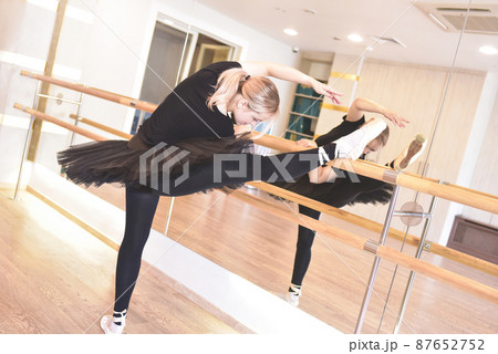 ballerina in black wear is practicing in the dance studio. woman in tutu and pointe shoes in a dance class. 87652752