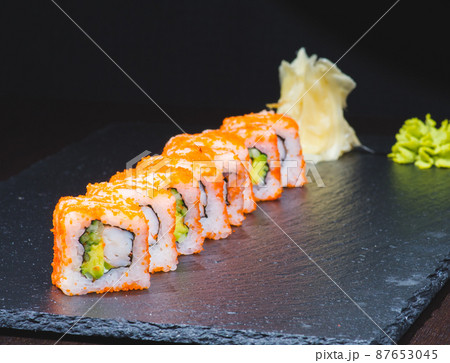 Traditional delicious fresh sushi roll set on a black background with reflection. Sushi roll with rice, cream chees, red fish, salmon. Sushi menu. Japanese kitchen, restaurant. Seafood, asian food 87653045