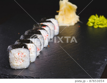 Traditional delicious fresh sushi roll set on a black background