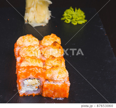 Sushi rolls california with snow crab, cream cheese, cucumber, sesame seeds and masago caviar on black background with reflection. Sushi menu, japanese kitchen. Sushi rolls california with snow crab, cream cheese, cucumber, sesame seeds and masago caviar on black background with reflection. Sushi menu, japanese kitchen. 87653060