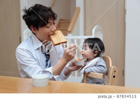 赤ちゃんに離乳食を食べさせる朝寝坊したパパ 赤ちゃんに離乳食を食べさせる朝寝坊したパパ 87654513