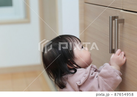 引き出しの扉をいたずらする赤ちゃん 引き出しの扉をいたずらする赤ちゃん 87654958