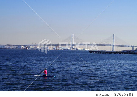 快晴の横浜ベイブリッジとSUPを楽しむ人物 快晴の横浜ベイブリッジとSUPを楽しむ人物 87655382
