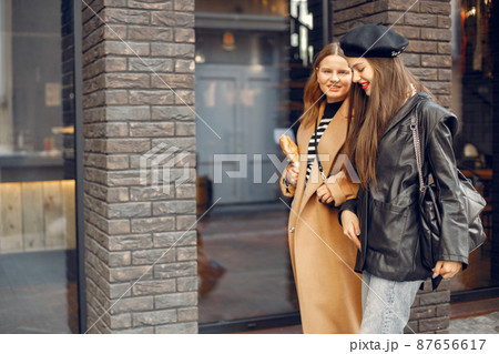 Two female friends in fashion clothes walking on the street 87656617