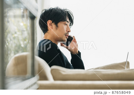 リビングで電話をする男性 リビングで電話をする男性 87658049