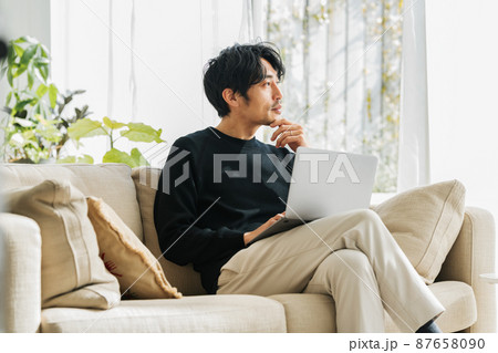 自宅のソファーでテレワークするミドル男性 87658090