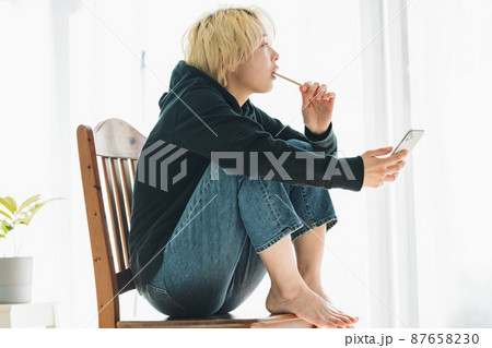 スマホを持ちながら歯を磨く女性 87658230