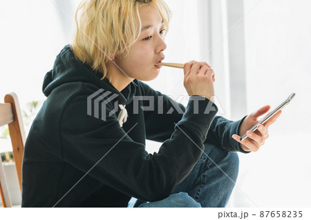 スマホを持ちながら歯を磨く女性 87658235