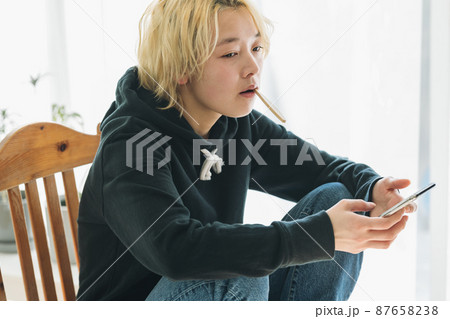 スマホを持ちながら歯を磨く女性 87658238