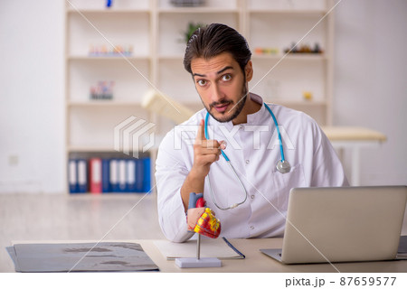 Young male doctor cardiologist working in the clinic Young male doctor cardiologist working in the clinic 87659577