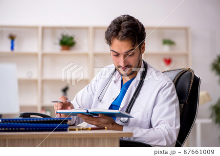 Young male doctor working in the clinic 87661009