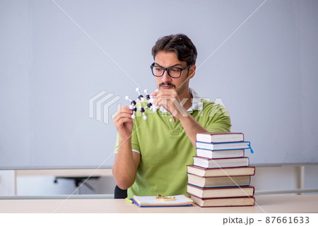 Young male student chemist preparing for exams in the classroom Young male student chemist preparing for exams in the classroom 87661633