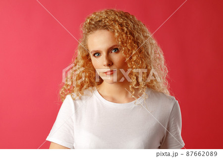 Gorgeous beautiful young woman with curly hair posing at camera 87662089