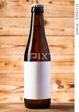 Blank label on the beer bottle on wooden background. Blank label on the beer bottle on wooden background. 87662119