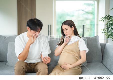 スマホを見る妊婦と男性（悩む） 87662155