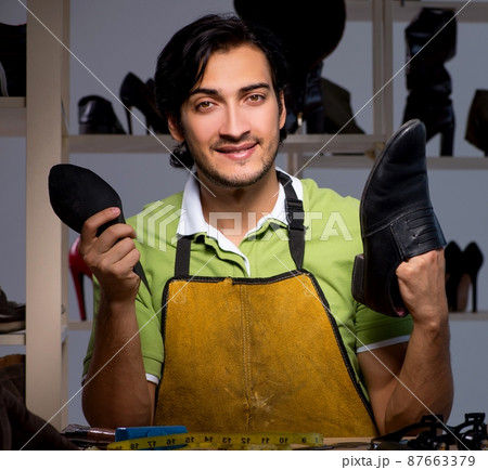 Young shoemaker in workshop at night Young shoemaker in workshop at night 87663379