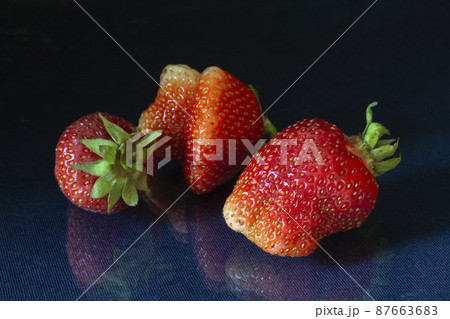 Ripe strawberries with reflection on black background Ripe strawberries with reflection on black background 87663683
