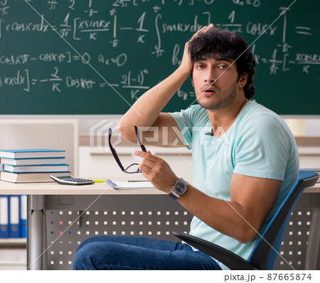 Young male student mathematician in front of chalkboard 87665874