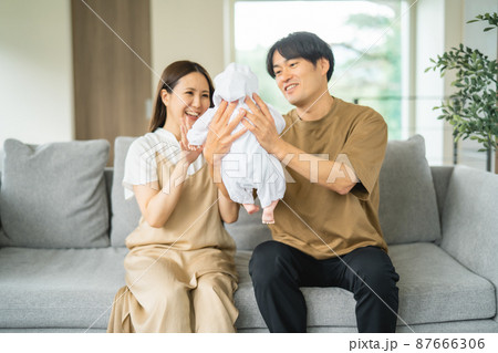 ソファで赤ちゃんを抱く男女 ソファで赤ちゃんを抱く男女 87666306
