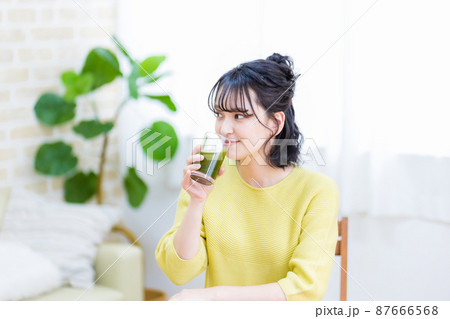 健康のため青汁を飲む若い女性 87666568